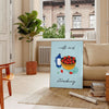 A colorful illustration of milk and strawberries with green and orange tones - in a Parisian living room with a sofa and a fig plant