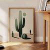 Minimalist cactus illustration in black and gray tones - beside a round wooden side table with books