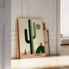 A minimalist cactus illustration in black and gray tones - leaning on a herringbone floor against a white panelled wall