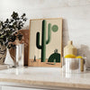 A minimalist cactus illustration in black and gray tones - styled on a counter with eucalyptus and a bowl of lemons