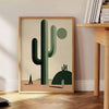 A minimalist cactus illustration in black and gray tones - beside a round wooden side table with books