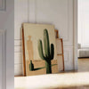 Illustration minimaliste d'un cactus en tons verts et noirs - posée sur un parquet à chevrons contre un mur à moulures