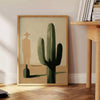 Illustration minimaliste d'un cactus en tons verts et noirs - à côté d'une table d'appoint ronde en bois avec des livres