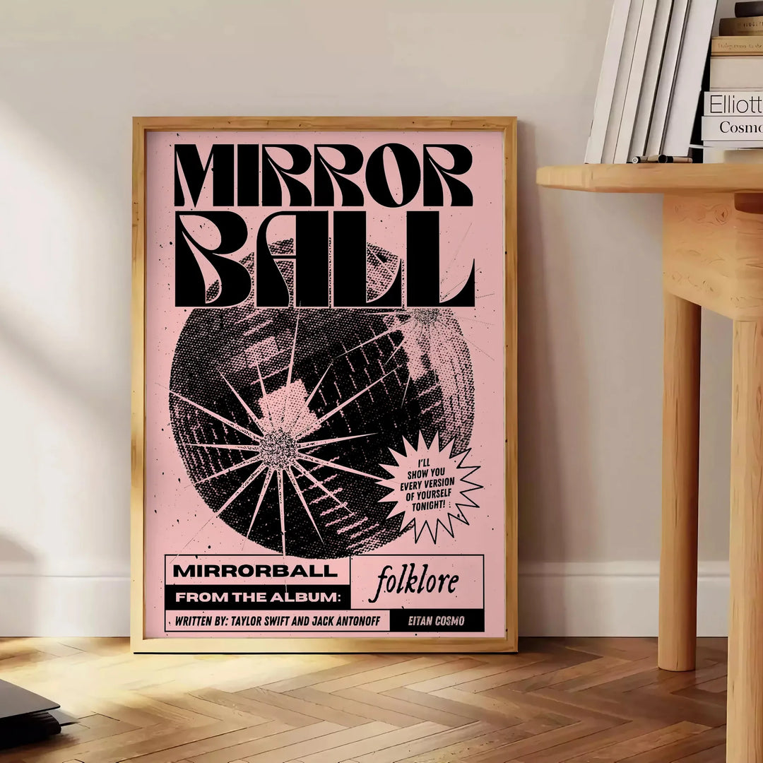 A reflective disco ball surrounded by abstract black and orange patterns - beside a round wooden side table with books