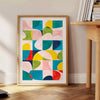 composição abstrata com formas azuis e laranjas em um estilo moderno - ao lado de uma mesa de apoio redonda em madeira com livros