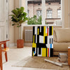 Abstract composition with orange and black shapes in a modern style - in a Parisian living room with a sofa and a fig plant