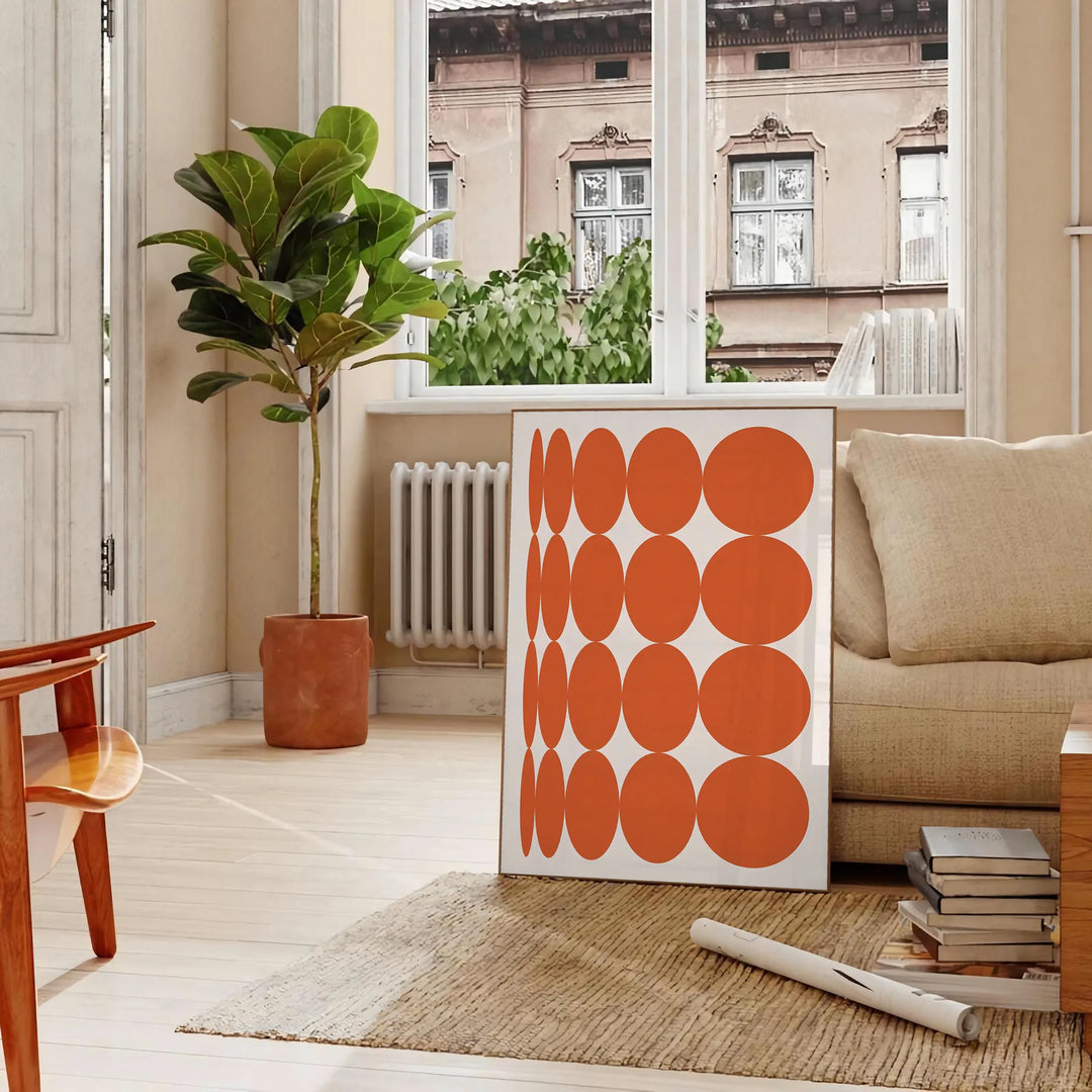 Abstract composition with orange and earthy brown tones in a modern style - in a Parisian living room with a sofa and a fig plant