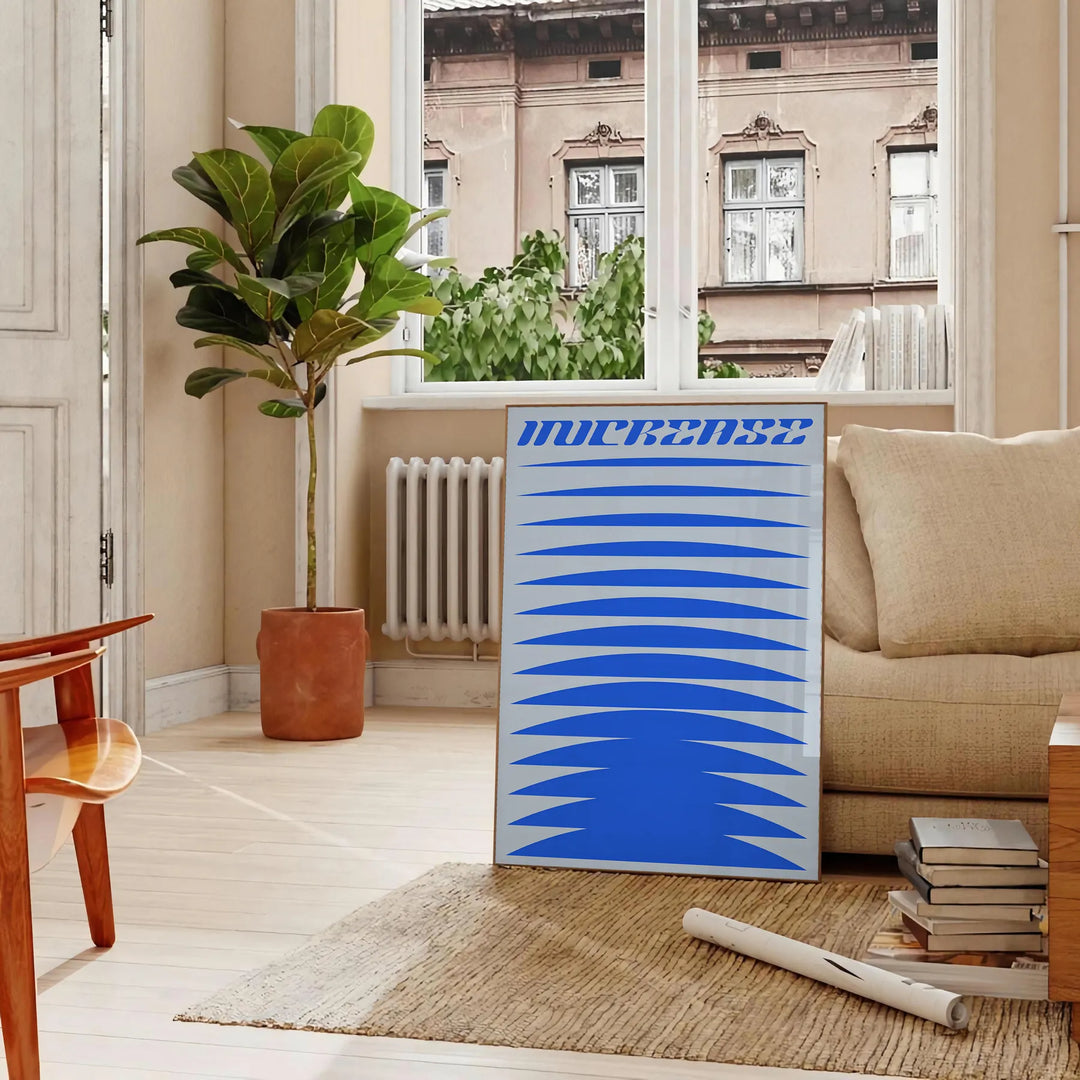 Abstract modern art with dynamic blue and gray shapes - in a Parisian living room with a sofa and a fig plant