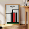 Abstract composition with bold black and red shapes on a white background - beside a round wooden side table with books