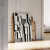 Abstract composition with black and orange shapes in a modern style - leaning on a herringbone floor against a white panelled wall
