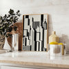 Abstract composition with black and orange shapes in a modern style - styled on a counter with eucalyptus and a bowl of lemons