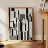 Abstract composition with black and orange shapes in a modern style - beside a round wooden side table with books