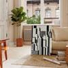 Abstract composition with black and orange shapes in a modern style - in a Parisian living room with a sofa and a fig plant