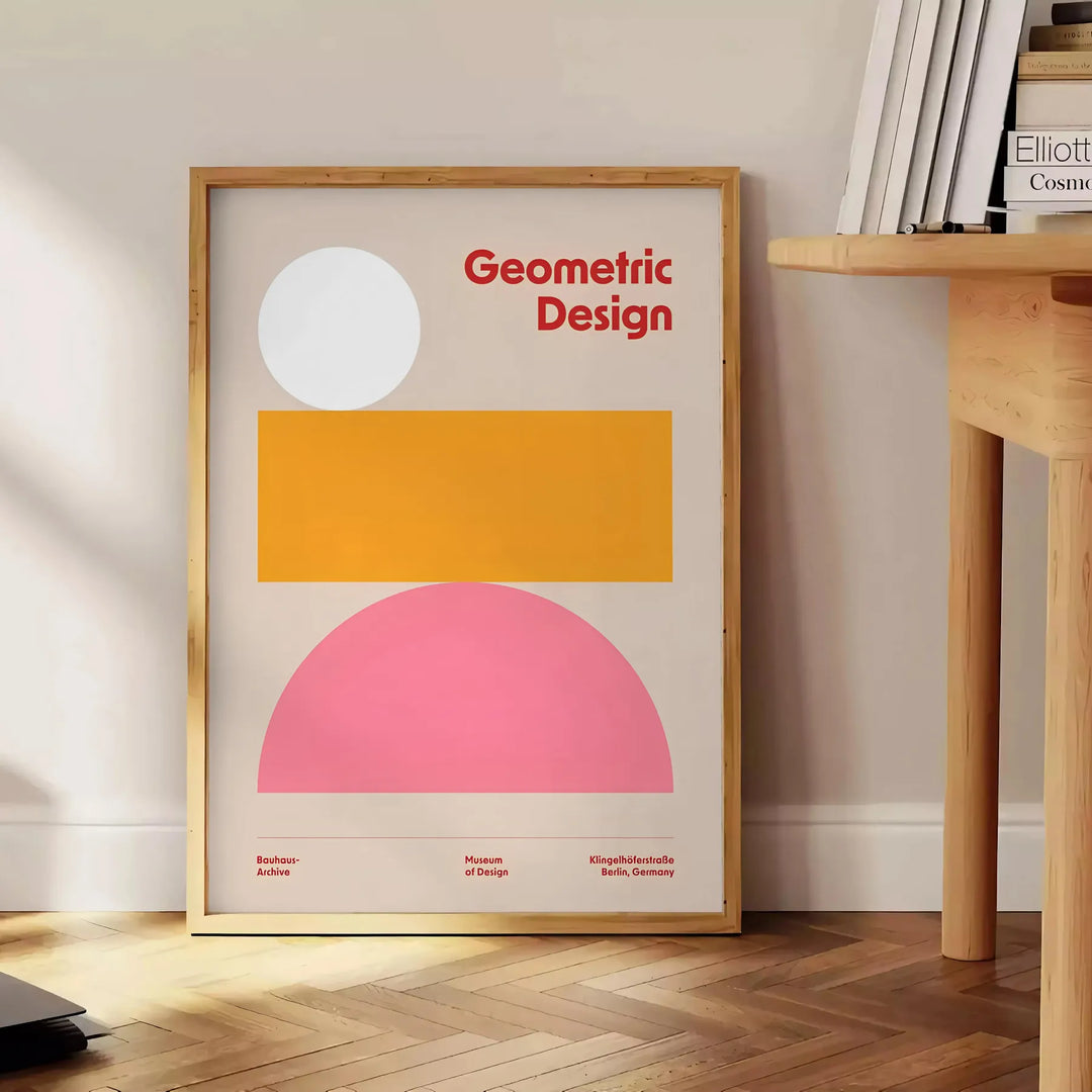 Abstract modern art with gray and orange hues depicting a cosmic theme - beside a round wooden side table with books