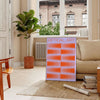 Abstract composition with orange and blue shapes in a modern style - in a Parisian living room with a sofa and a fig plant