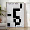 Abstract composition with black and blue shapes and lines - in a bright minimalist room with a plant and an armchair