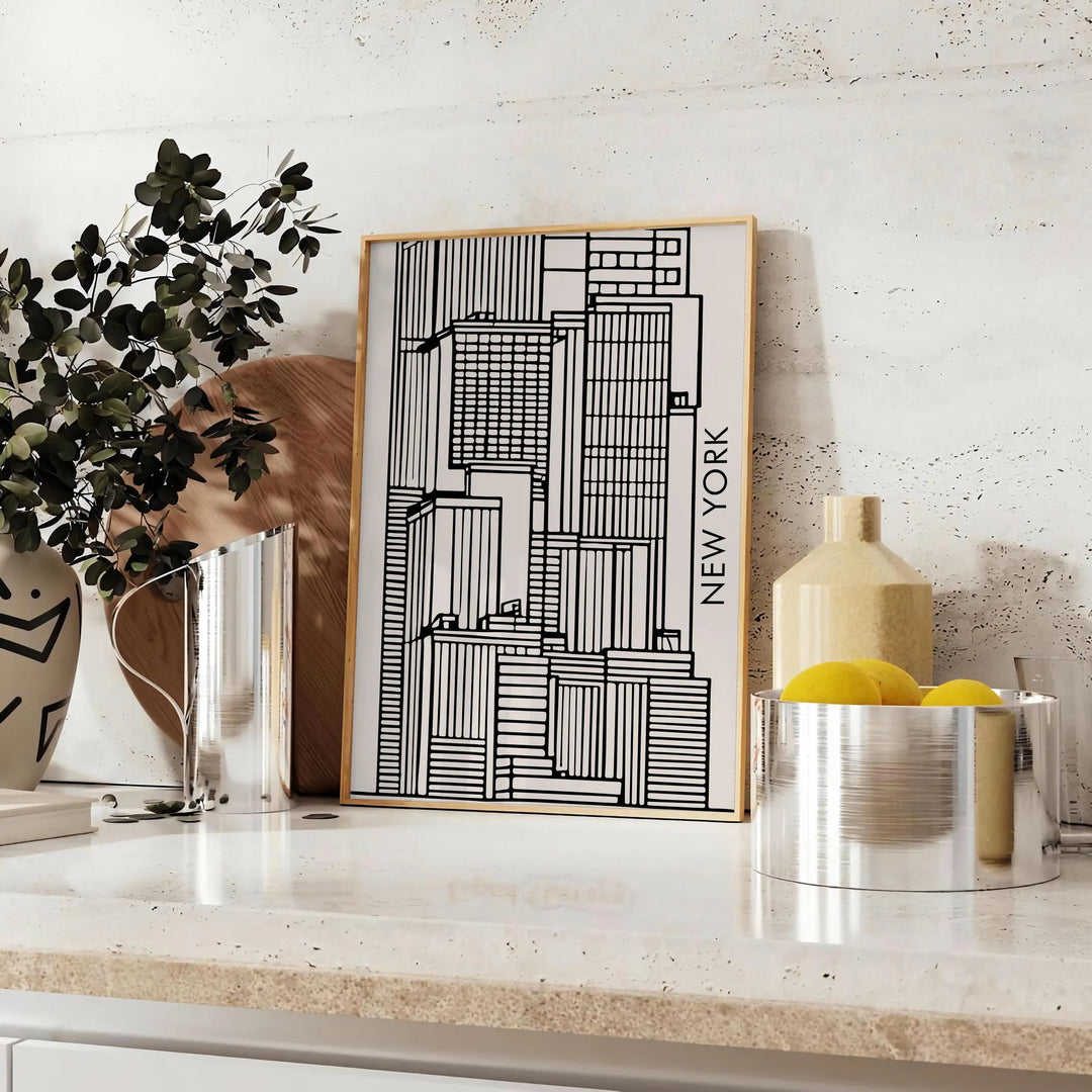 Abstract shapes in bold black and vibrant orange on a modern art poster - styled on a counter with eucalyptus and a bowl of lemons