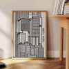 Abstract shapes in bold black and vibrant orange on a modern art poster - beside a round wooden side table with books