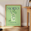 Un'illustrazione colorata di un cocktail Mojito con foglie di menta e fette di lime - accanto a un tavolino rotondo in legno con libri