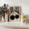 Abstract design featuring cherries in black and orange hues - styled on a counter with eucalyptus and a bowl of lemons