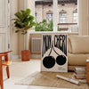 Abstract design featuring cherries in black and orange hues - in a Parisian living room with a sofa and a fig plant