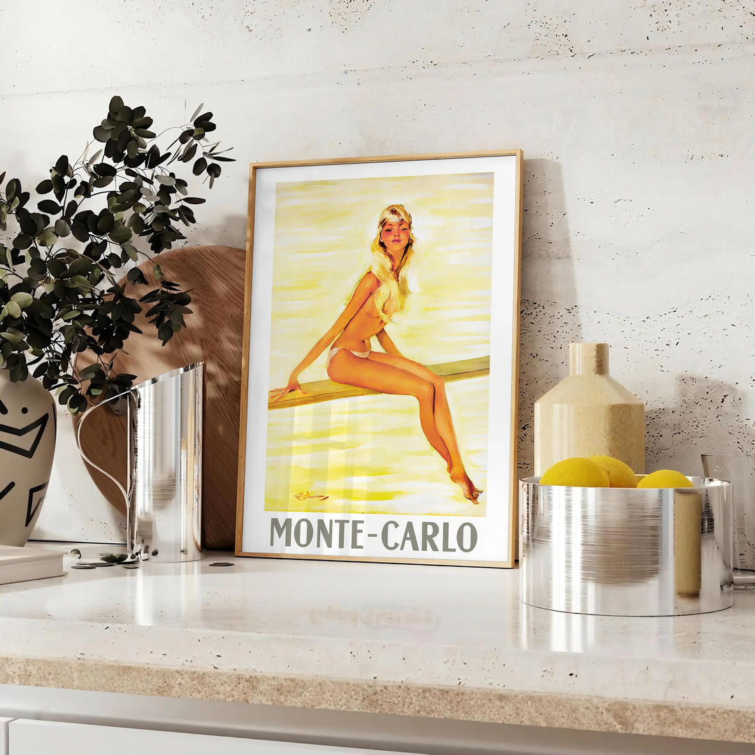 Vintage travel poster of Monte Carlo with warm brown and orange tones - styled on a counter with eucalyptus and a bowl of lemons