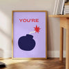 Abstract design featuring orange and blue tones with motivational text - beside a round wooden side table with books