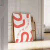 Red and white motivational poster with abstract space elements and inspirational text - leaning on a herringbone floor against a white panelled wall