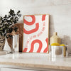 Red and white motivational poster with abstract space elements and inspirational text - styled on a counter with eucalyptus and a bowl of lemons