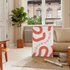 Red and white motivational poster with abstract space elements and inspirational text - in a Parisian living room with a sofa and a fig plant