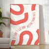Red and white motivational poster with abstract space elements and inspirational text - in a bright minimalist room with a plant and an armchair