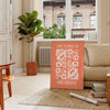 Abstract design with warm orange and brown tones promoting motivation - in a Parisian living room with a sofa and a fig plant
