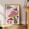 Colorful mushrooms in Yayoi Kusama's signature polka dot style - beside a round wooden side table with books