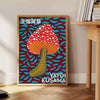 Colorful mushroom pattern with polka dots by Yayoi Kusama - beside a round wooden side table with books