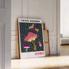 Colorful mushroom pattern with polka dots by Yayoi Kusama - leaning on a herringbone floor against a white panelled wall