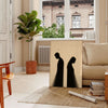 Minimalistische menschliche Figur in Schwarz- und Orangetönen - in einem Pariser Wohnzimmer mit Sofa und einer Geigenfeige