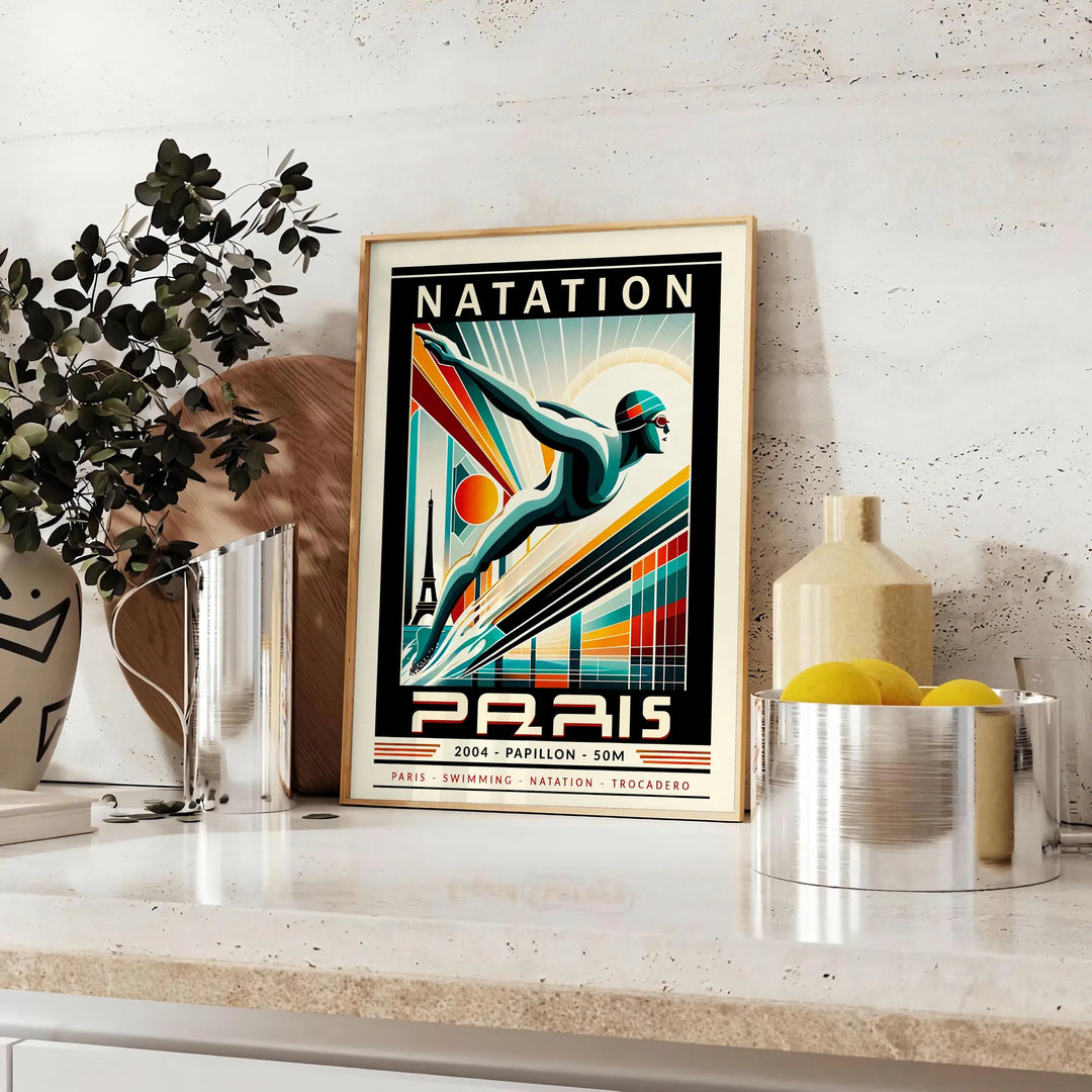 Red and white stylized butterfly stroke swimmer poster for 50 meters - styled on a counter with eucalyptus and a bowl of lemons
