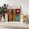 Abstract nature scene with polka dots in orange and green by Yayoi Kusama - styled on a counter with eucalyptus and a bowl of lemons