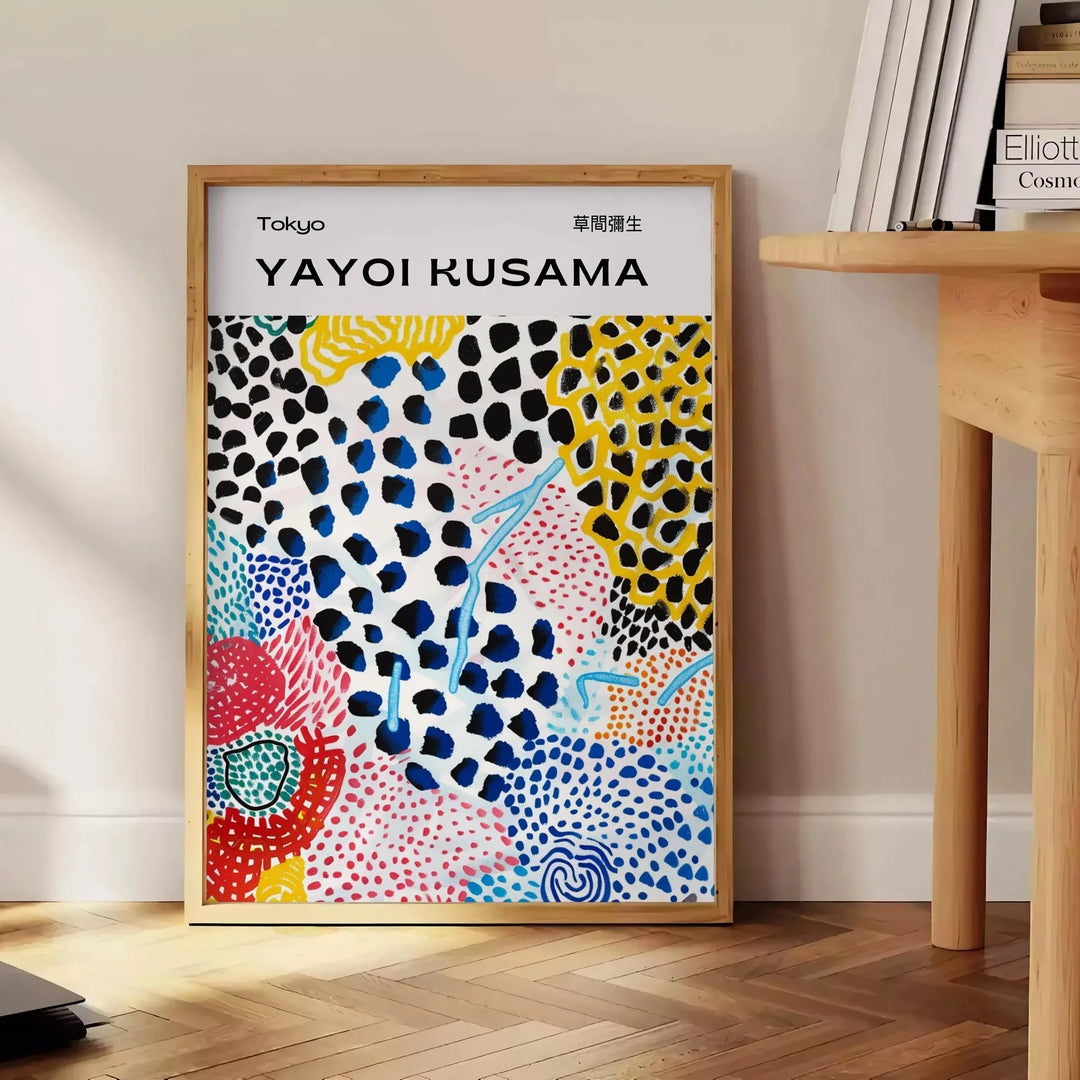 Colorful abstract nature scene by Yayoi Kusama with polka dots - beside a round wooden side table with books