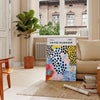 Colorful abstract nature scene by Yayoi Kusama with polka dots - in a Parisian living room with a sofa and a fig plant