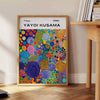 Abstract nature scene in Yayoi Kusama's iconic polka dot style with blue and earthy tones - beside a round wooden side table with books