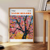 Abstract nature scene with polka dots in green and white by Yayoi Kusama - beside a round wooden side table with books