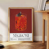 A colorful illustration of a Negroni cocktail in a glass with orange garnish - beside a round wooden side table with books