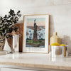 A travel poster featuring New York City with green and blue hues - styled on a counter with eucalyptus and a bowl of lemons