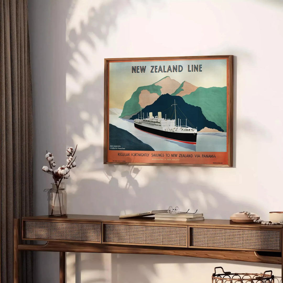Un cartel de viaje de estilo vintage que muestra los paisajes exuberantes de Nueva Zelanda en verdes y naranjas cálidos - sobre una encimera con eucalipto y un cuenco de limones