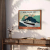 Un cartel de viaje de estilo vintage que muestra los paisajes exuberantes de Nueva Zelanda en verdes y naranjas cálidos - sobre una encimera con eucalipto y un cuenco de limones