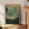 A vintage travel poster featuring Niagara Falls with green and gray tones - beside a round wooden side table with books