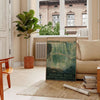 A vintage travel poster featuring Niagara Falls with green and gray tones - in a Parisian living room with a sofa and a fig plant
