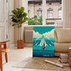 A sailor navigating a boat on the ocean, with orange and blue tones - in a Parisian living room with a sofa and a fig plant