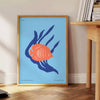 A colorful depiction of ocean wildlife featuring orange and blue hues - beside a round wooden side table with books